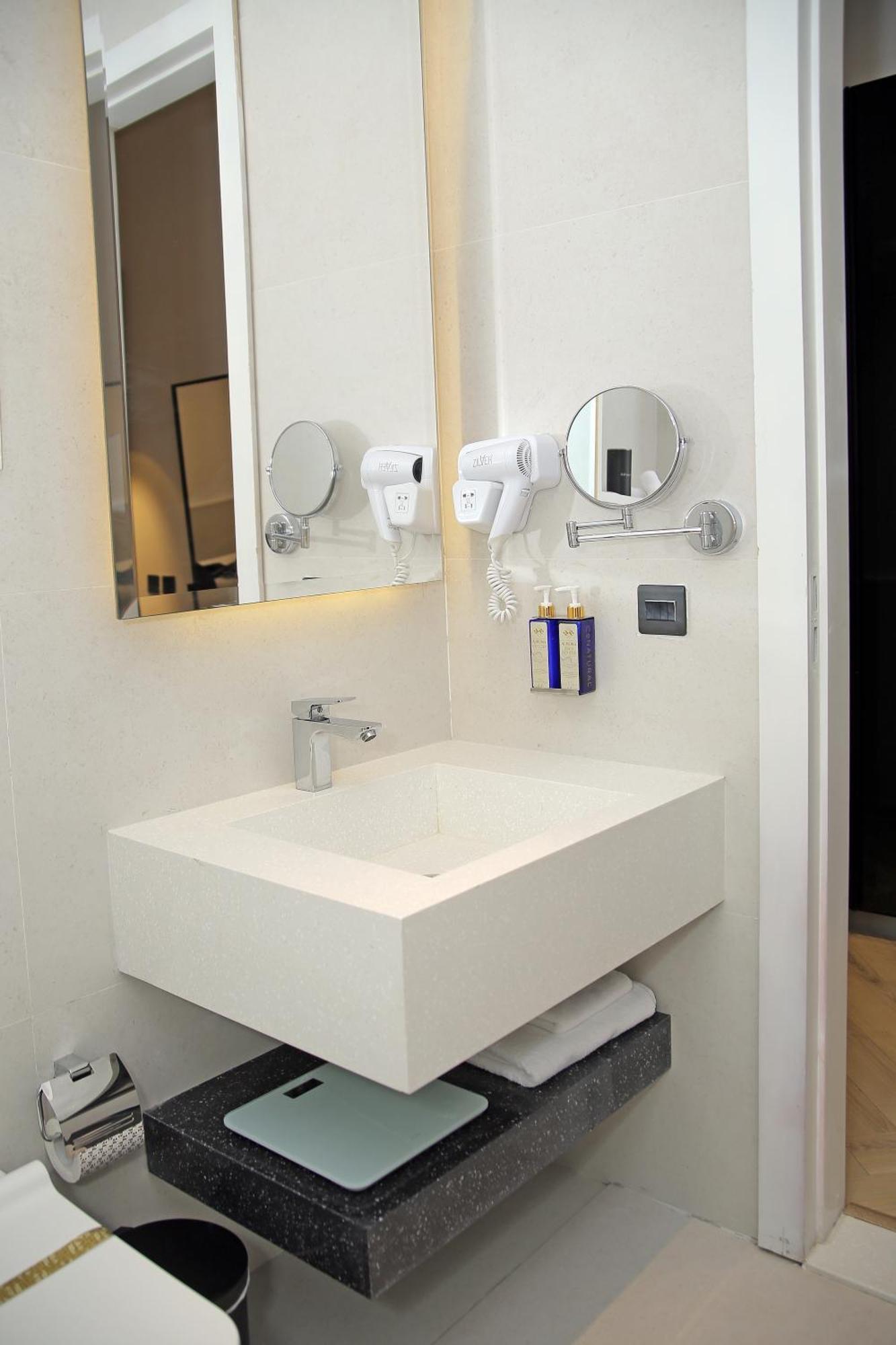 Ambiance Boutique Art Hotel Lahore Værelse billede A wall mounted hair dryer in a hotel bathroom